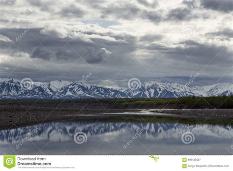 Spring Mountains With Remnants Of Snow And The Reflection In The River