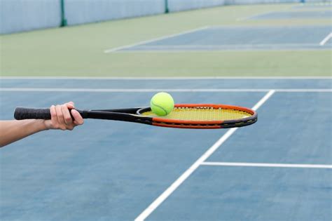 Man Holding Racket About To Hit A Ball In Tennis Court Free Photo