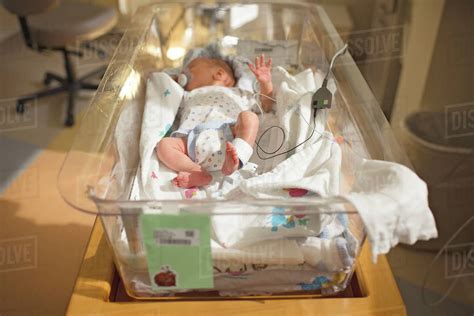 High Angle View Of Newborn Baby Boy Sleeping In Crib At Hospital