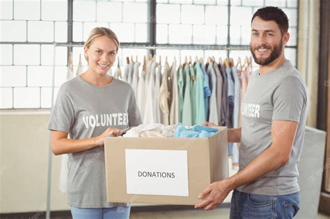 Premium Photo Portrait Of Smiling Volunteer Holding Clothes Donation Box