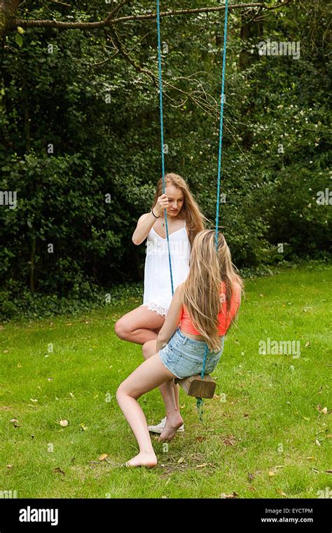 deux teenage girls playing on swing photo stock alamy