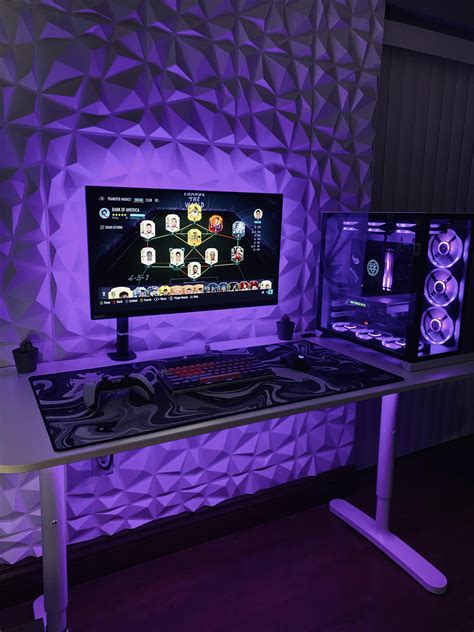A Desk With A Computer Monitor And Speakers On It In Front Of A Purple Wall