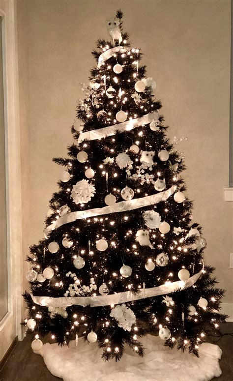 A Black And White Christmas Tree Decorated With Ornaments