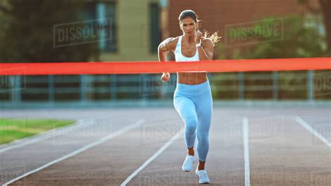 Beautiful Fit Female Runner Crossing The Finish Line On A Professional