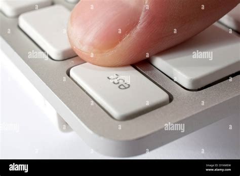 Finger Is Pressing Esc Key Of A Modern Stylish Aluminium White Computer