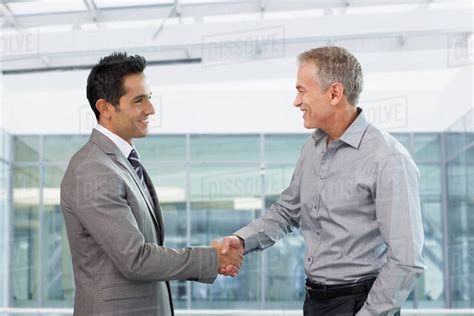 Two Businessmen Shaking Hands In Office Stock Photo Dissolve