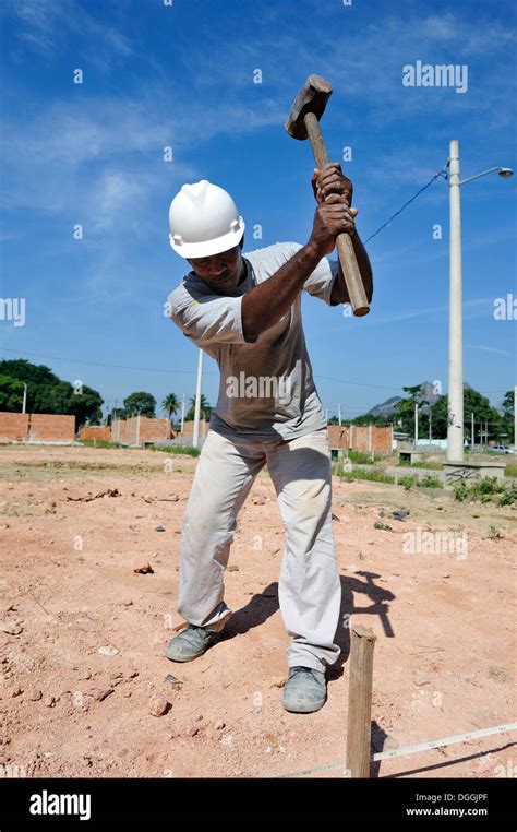 Man With A Sledge Hammer Hitting A Peg In The Ground People From The