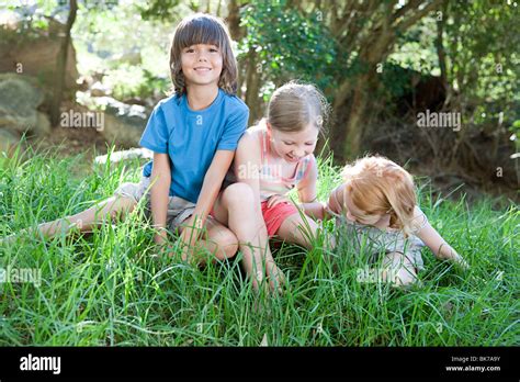 Children Sitting On Grass Stock Photo Alamy