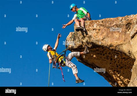 Climbing Team Struggle To The Summit Of A Challenging Rock Mountain