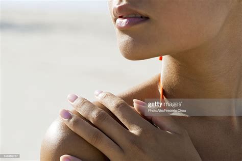 Woman Touching Bare Shoulder At The Beach Cropped Photo Getty Images