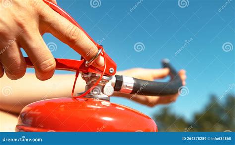 Macro Young Woman Pulls Safety Pin Out Of A Fire Extinguisher Before Using It Stock Image