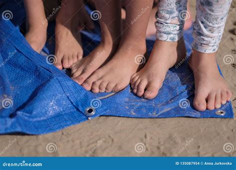 Children With Bare Feet Are Standing On A Blue Synthetic Coating Stock