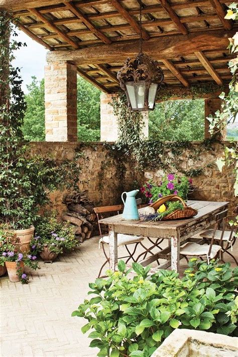 Outdoor Patio With Rustic Table And Chairs Surrounded By Potted Plants