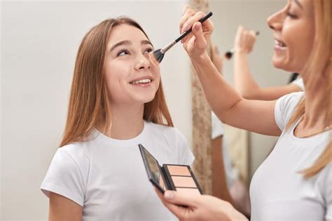 premium photo mother doing makeup for daughter at home