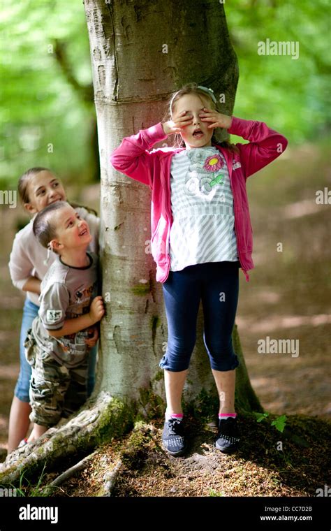 Children Play A Game Of Hide And Seek In The Woods Stock Photo Royalty
