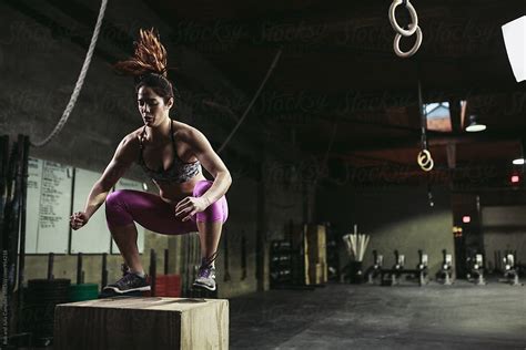 Active Fit Mixed Race Woman Training Hard On Box Jumps In Workout Gym