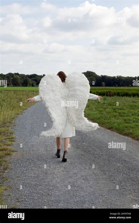 Carefree Angel With Arms Outstretched Walking On Road Stock Photo Alamy