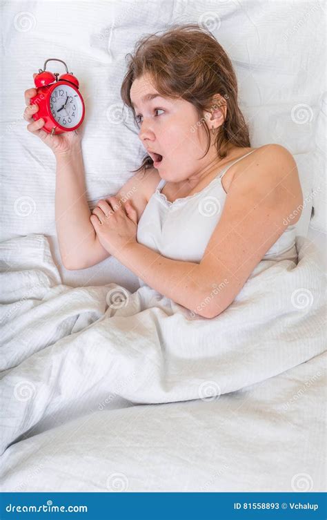 Young Woman Is Waking Up And Looking At Clock She Oversleep And Is