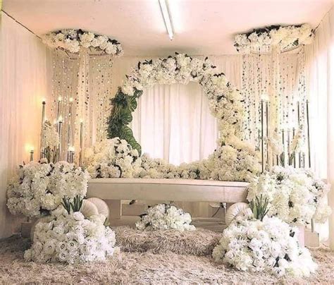 White Flowers And Candles Are Arranged In Front Of A Mirror On The