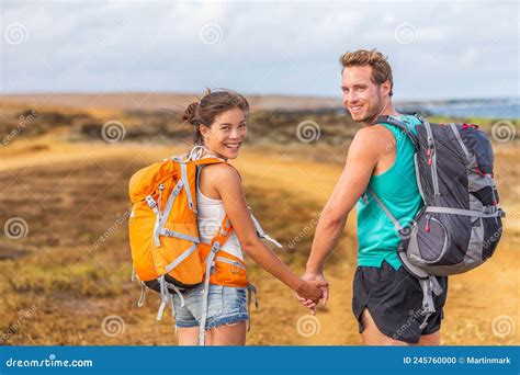 Happy Young Couple Tourists In Love Holding Hands Walking On Trek Hike