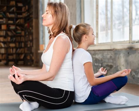 Madre E Hija Meditando Espalda Con Espalda Sobre Colchonetas De Yoga