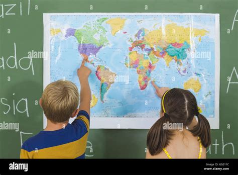 School Kids Pointing At Map In Classroom Stock Photo Alamy