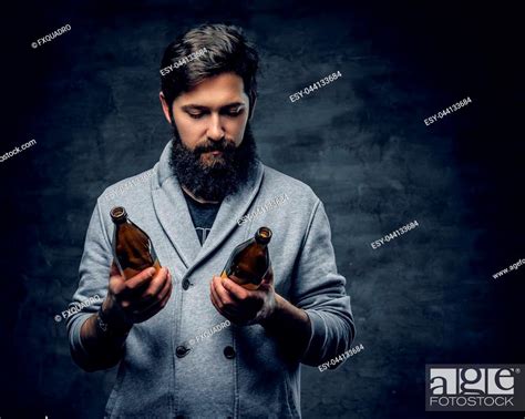 Full Throttle Bearded Male Holds Two Craft Beer Bottles And Looking On