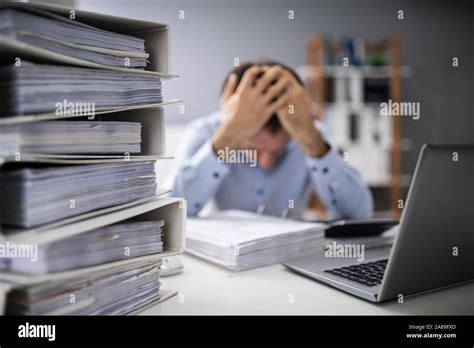 Photo Of Overworked Businessman Doing Taxes At Office Stock Photo Alamy