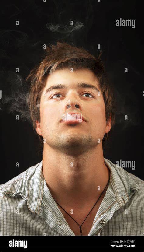 Young Man Smoking And Puffing Smoke From Mouth Stock Photo Alamy