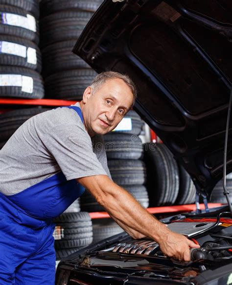 Professional Mature Man Car Mechanician Repairing Car In Auto Repair