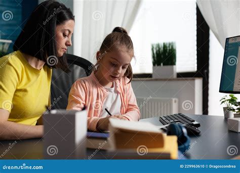 Madre Ayudando A Su Hija Pequeña Con Los Deberes Escolares Foto De