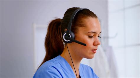 Portrait Of Medical Receptionist Answering Pressing On Headphone