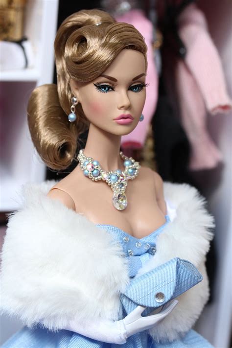 a barbie doll wearing a blue dress and white fur stole with jewels on her neck