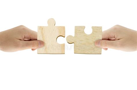 Hand Holding Wooden Jigsaw Puzzle And Combining Jigsaw Pieces Together
