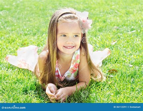 Cute Smiling Little Girl Lying On Grass Stock Image