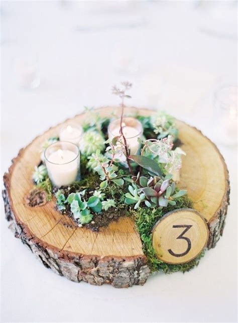 A Rustic Wedding Centerpiece With Moss Woodsy Table Number And
