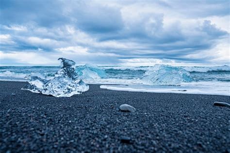 Premium Photo Iceberg Chunks On Black Sand Beach With Waves Rushing