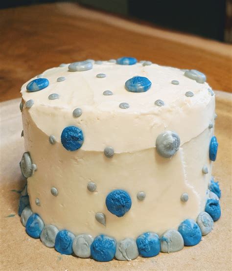 A White Cake With Blue Frosting And Polka Dots