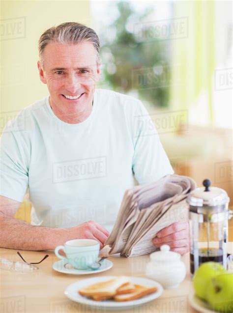 Portrait Of Man Reading Newspaper And Having Breakfast Stock Photo