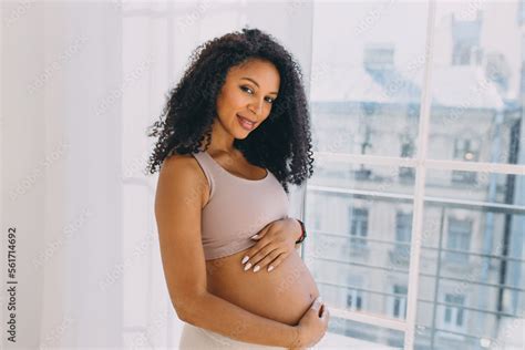 Horizontal Portrait Of Black Gorgeous Pregnant Female With Long Curls