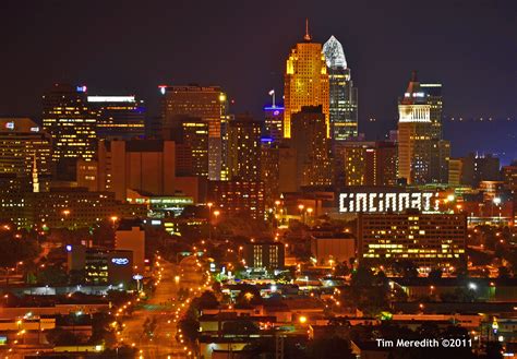 The City Skyline Is Lit Up At Night With Bright Lights And Buildings In