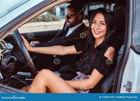 beautiful well dressed couple sitting on the front seats in the luxury car stock image image