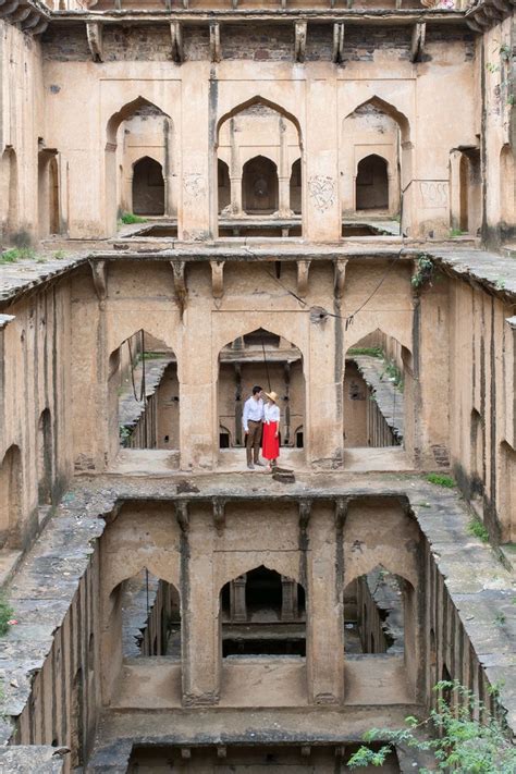 Two People Standing On The Balcony Of An Old Building