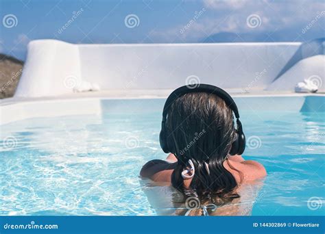 woman in the headphones listening to the music bathing in a pool stock image image of tropical
