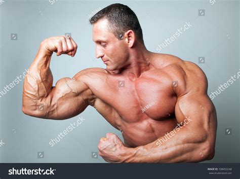 Muscular Man Flexing His Biceps Studio Shot Stock Photo 108453248