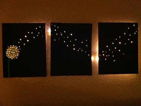 Three Canvases With Lights On Them In The Shape Of Dandelions And Stars