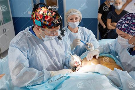 A Surgeon With An Assistant Operates On The Female Breast Mammoplasty