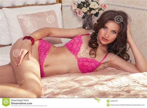 Woman With Dark Hair In Lingerie Posing At Bedroom Stock