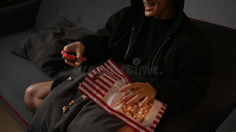 homem feliz com controle remoto comendo pipoca e assistindo filme na sala de estar atividades