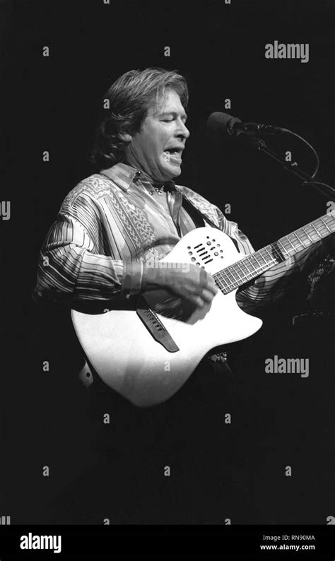 Singer Songwriter John Denver Is Shown Performing On Stage During A